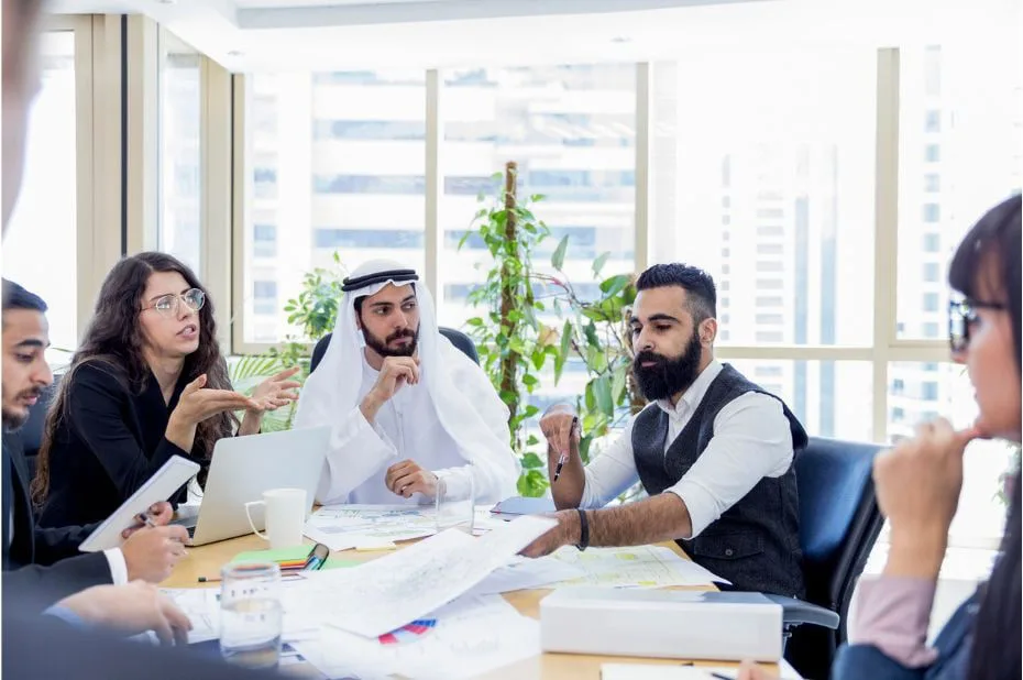 Diverse business team meeting in modern office discussing strategies for optimal solutions.